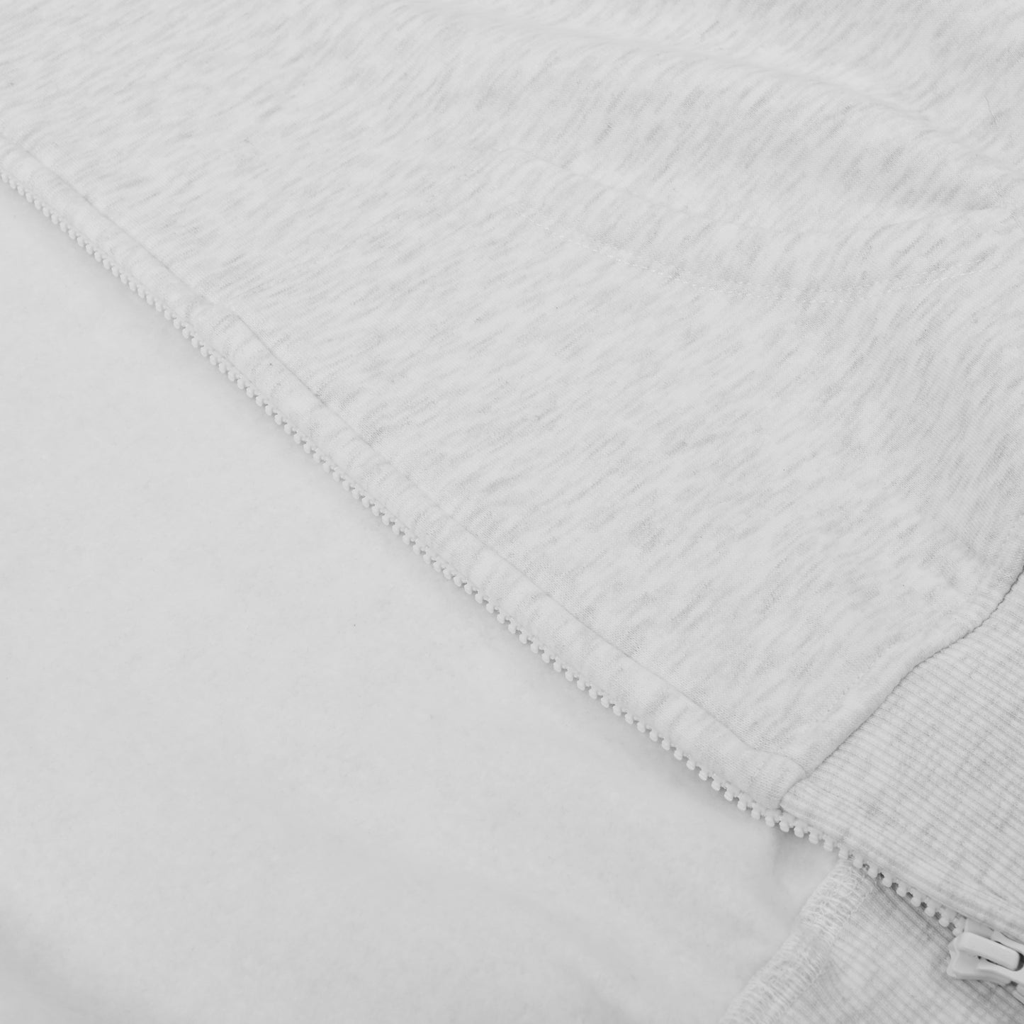 Close-up of a textured white fabric with a zipper