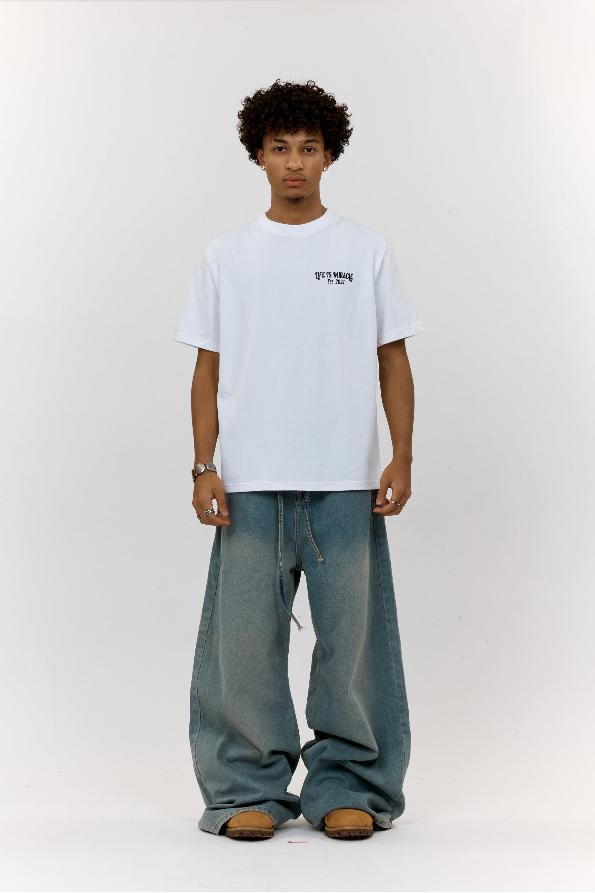 Person wearing a white t-shirt and blue jeans on a white background