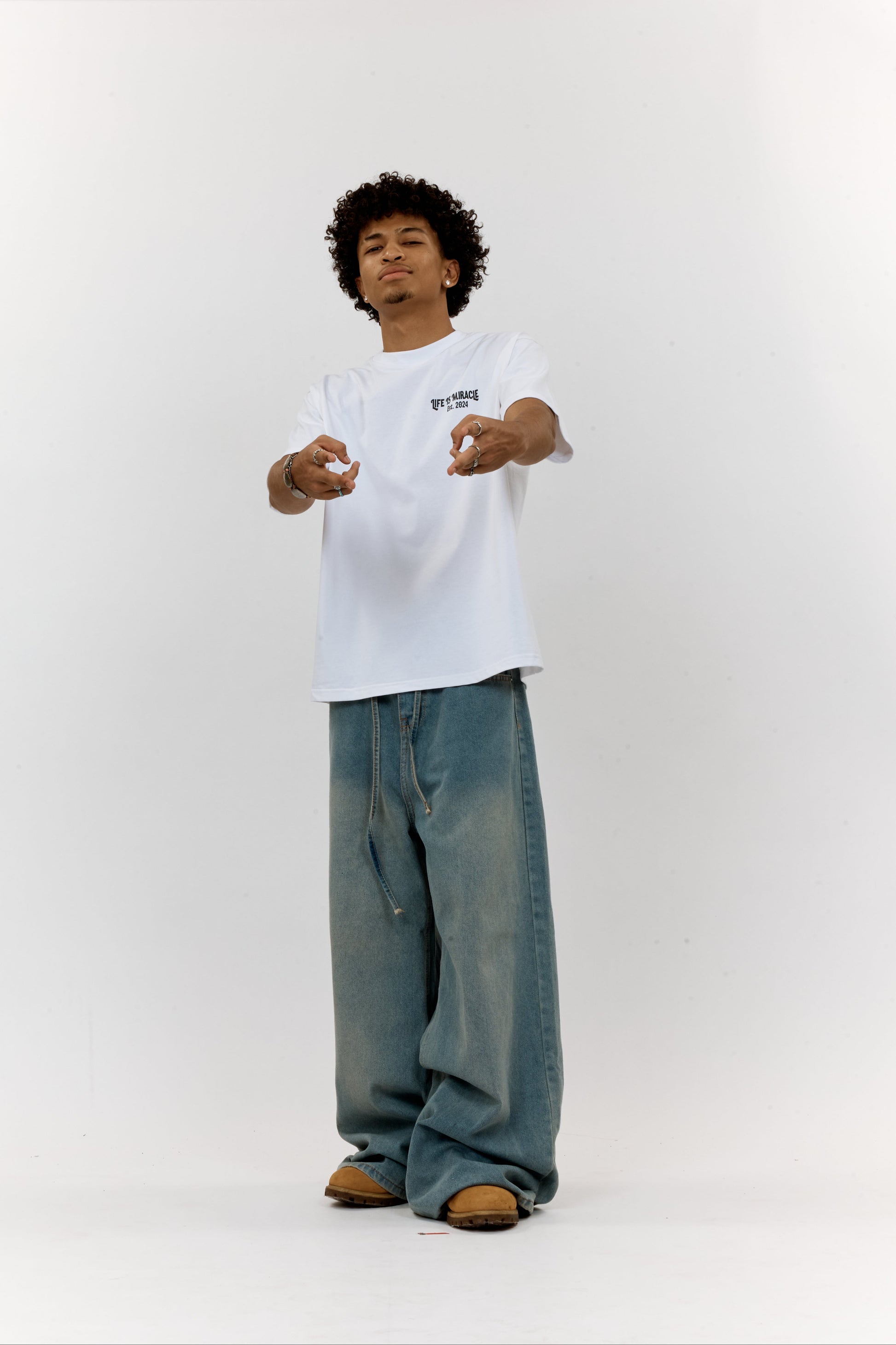Person wearing a white t-shirt and blue jeans on a white background