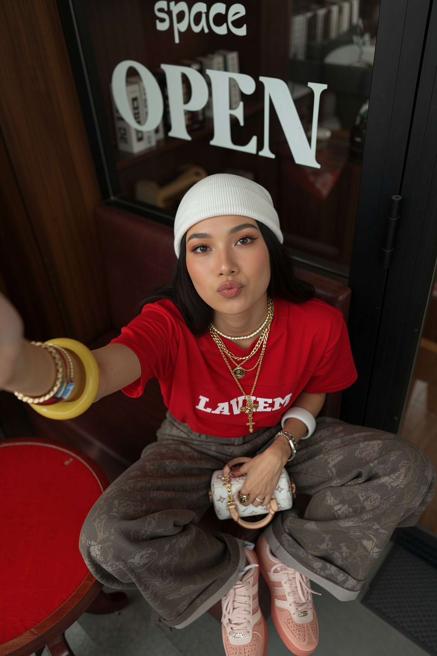 Person wearing a red shirt with 'LAVEN' text, sitting in a casual setting.