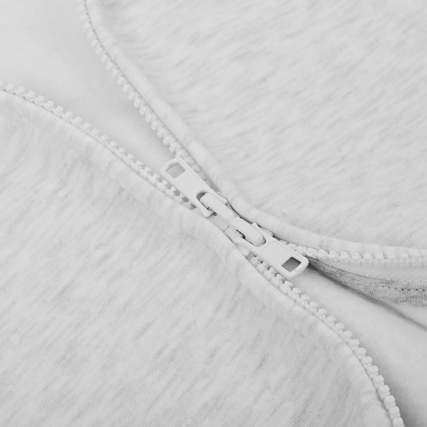 Close-up of a zipper on a light gray fabric background