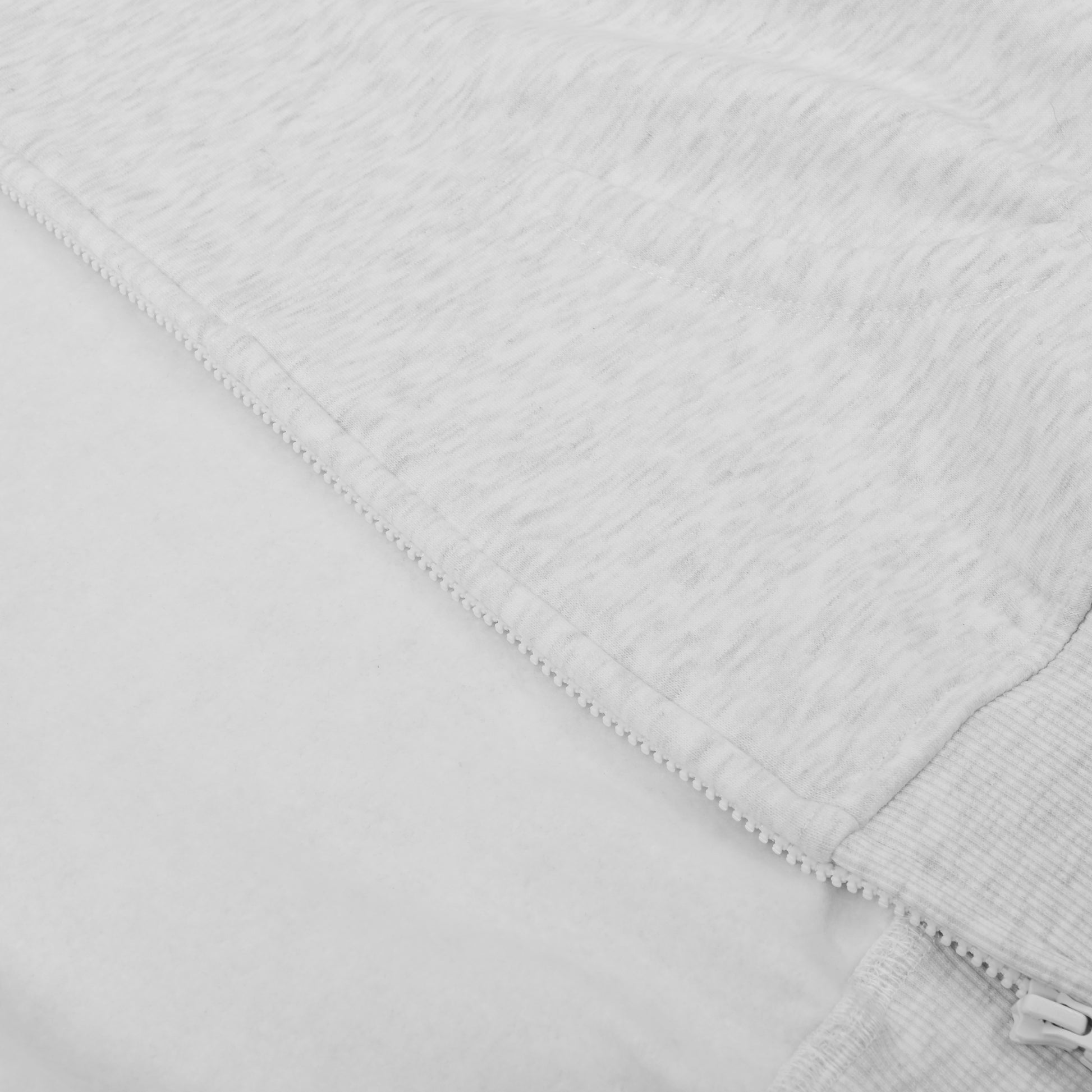 Close-up of a textured white fabric with a zipper