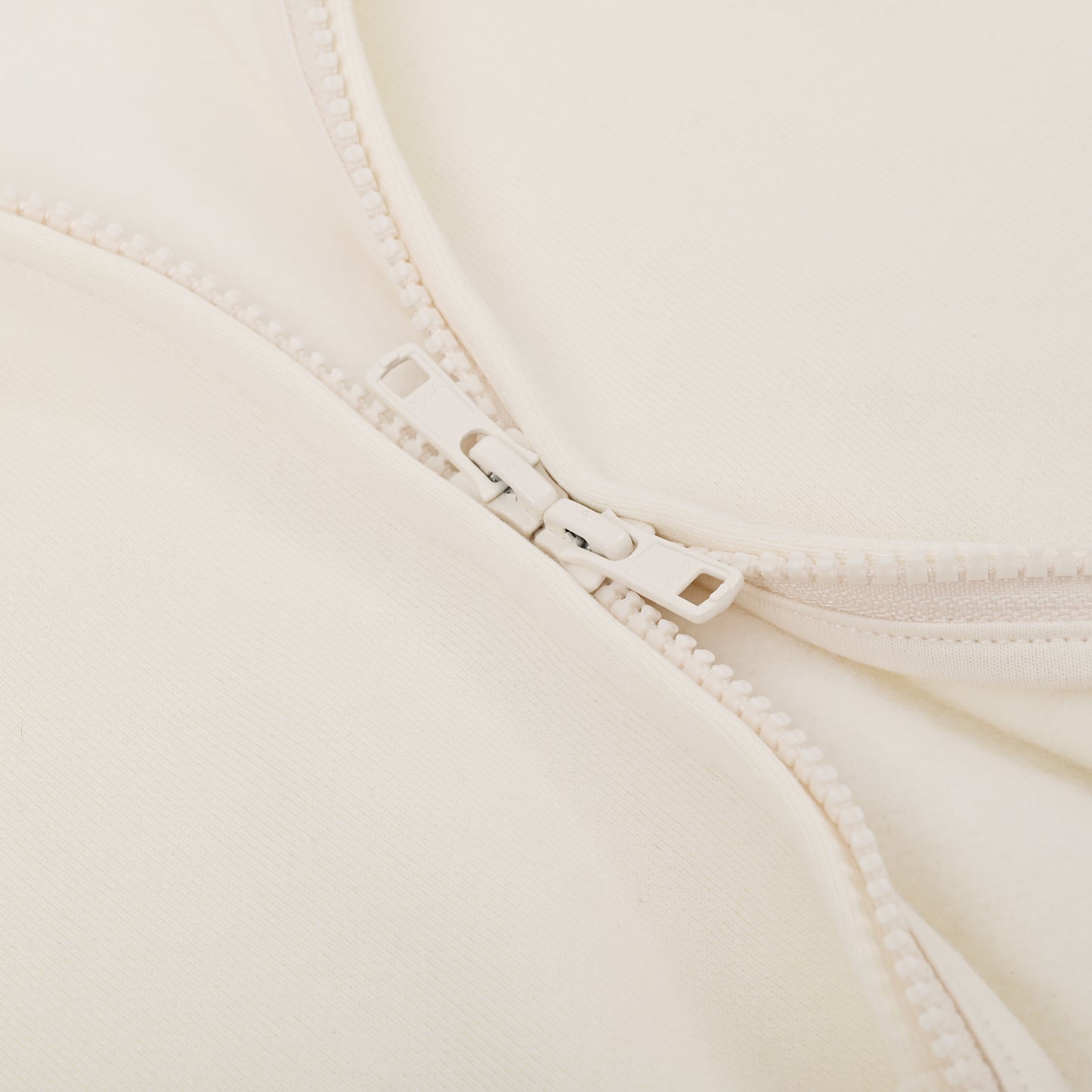 Close-up of a beige bra with a zipper detail on a light background