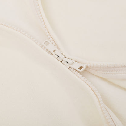 Close-up of a beige bra with a zipper detail on a light background