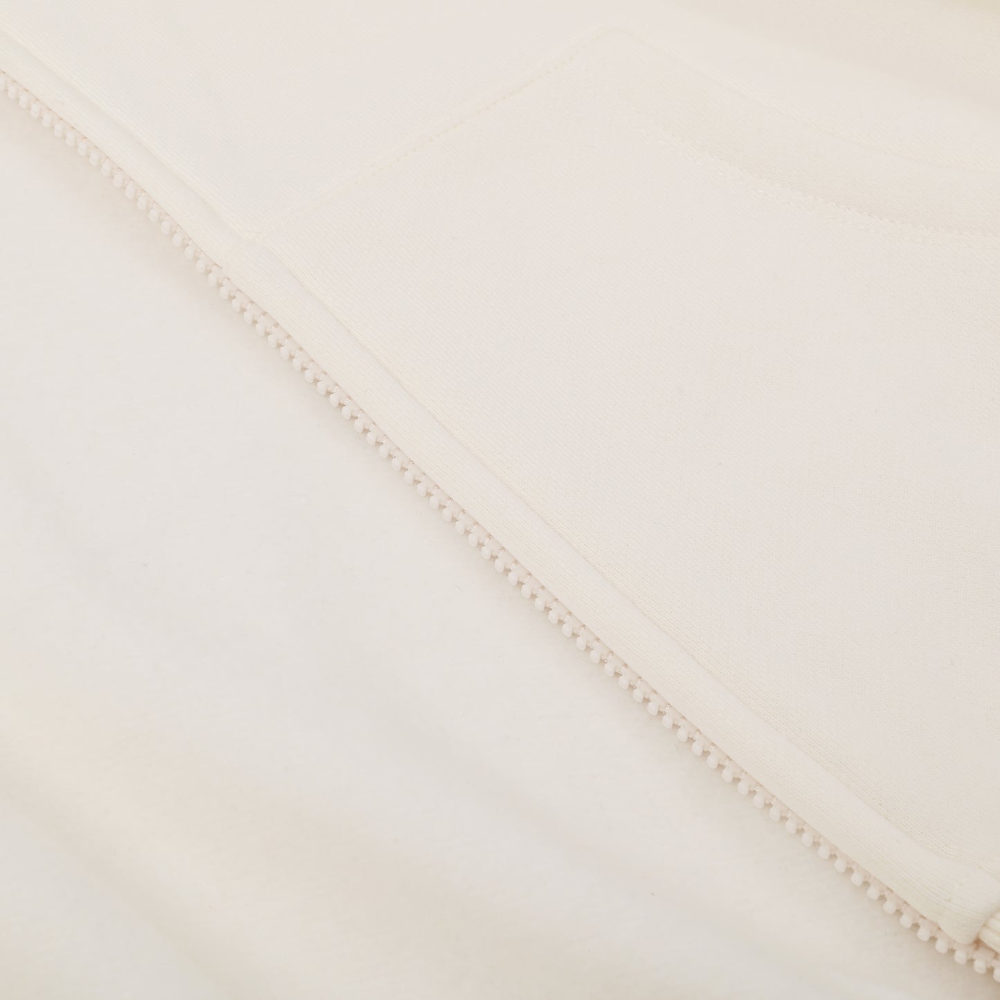 Close-up of a textured fabric with a subtle pattern on a light beige background