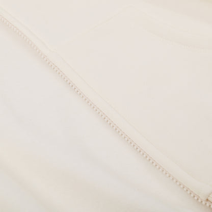 Close-up of a textured fabric with a subtle pattern on a light beige background